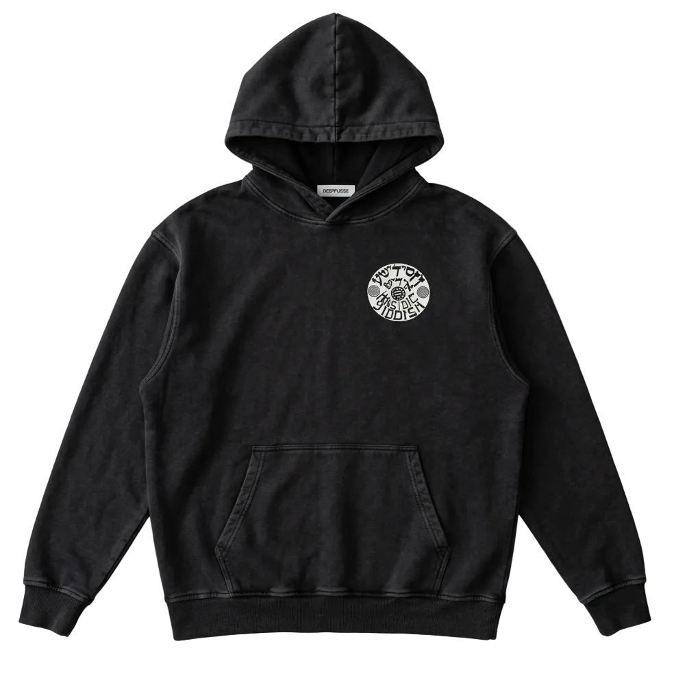 A black washed pullover hoodie with a circular white graphic on the left chest, laid flat on a light gray fabric background.