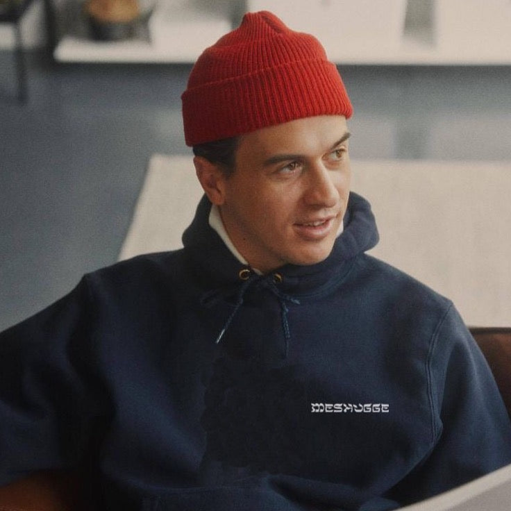 Man wearing the navy meshugge hoodie medium shot