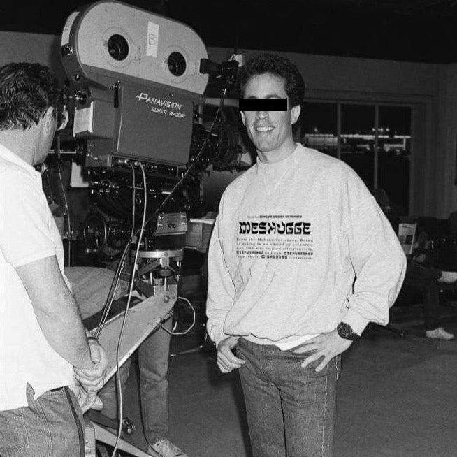 Man on a TV shoot wearing a Meshugge definition sweatshirt, black and white picture