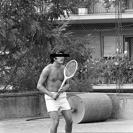 Black and White picture of a Shirtless man playing tennis