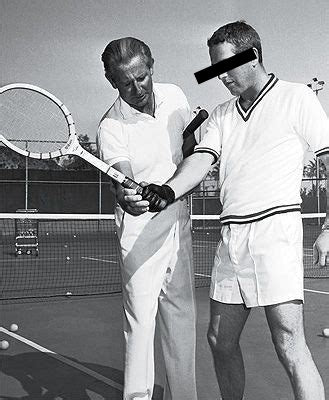 Two men on a tennis court with one holding a racket