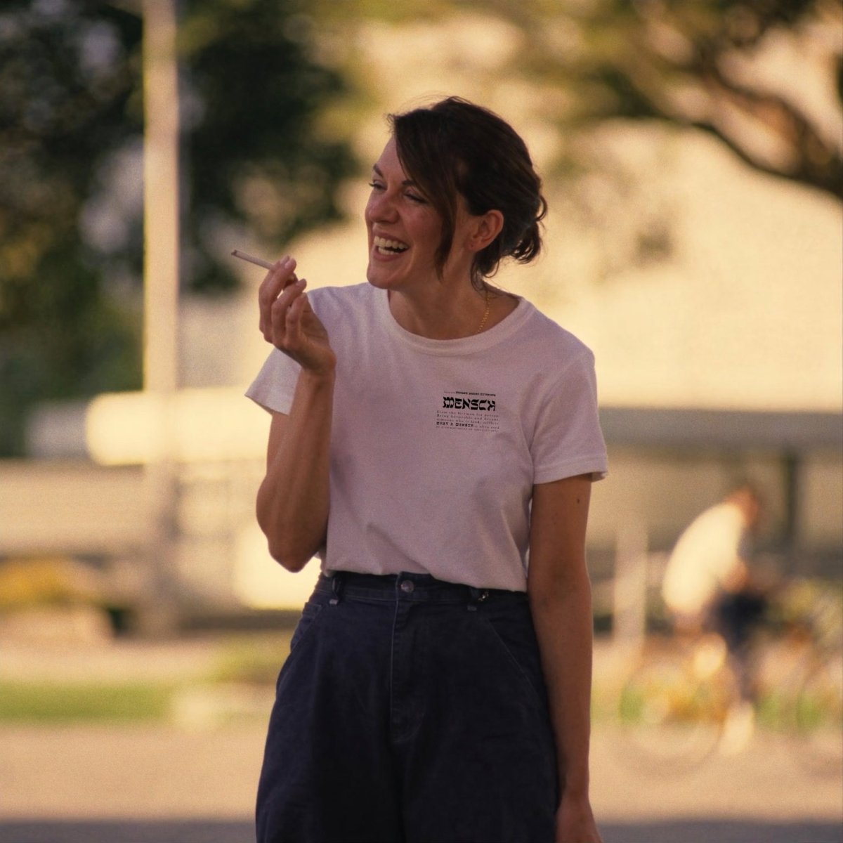 Woman smoking wearing mensch heart t-shirt in white