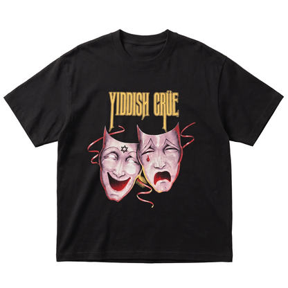 A black short-sleeve t-shirt with a graphic print featuring the words 'YIDDISH CRUE' in gold above two theatrical comedy and tragedy masks in pink, red, and white, laid flat on a light gray background.