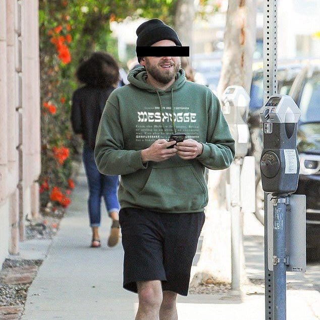 man wearing the bottle green Meshugge definition hoodie in the streets of Los Angeles