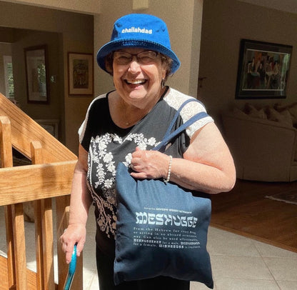older woman holding the black Meshugge definition tote