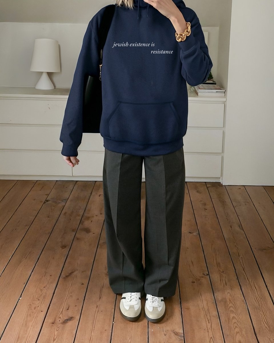 woman wearing Jewish Existence is Resistance hoodie navy