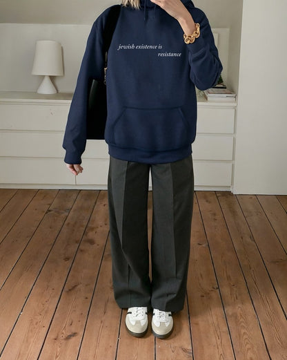 woman wearing Jewish Existence is Resistance hoodie navy
